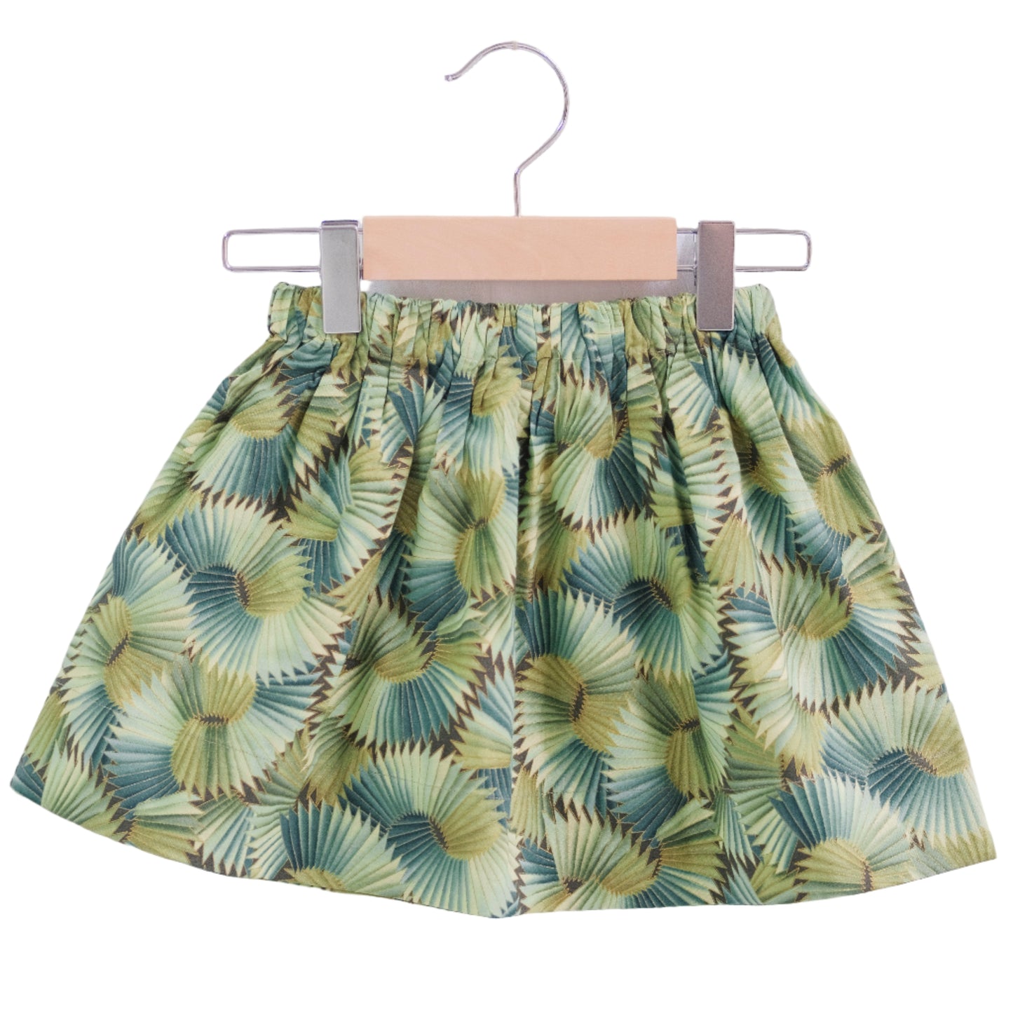 Green leaf-patterned skirt on a hanger against a white background
