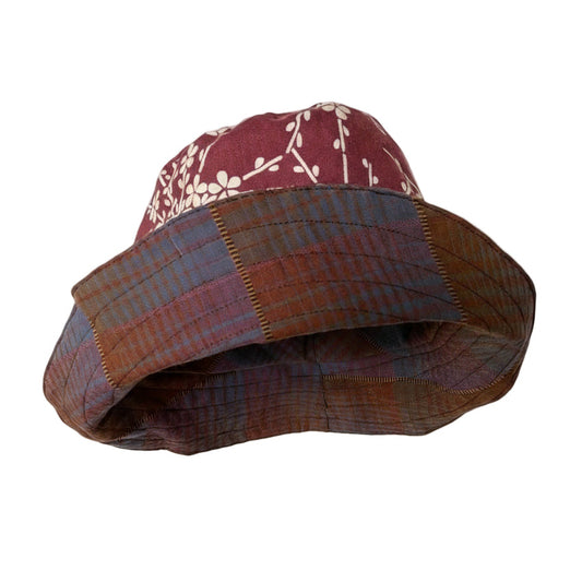 Plaid bucket hat on a mannequin stand against a plain background