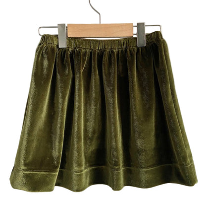 Green velvet skirt on a hanger against a white background