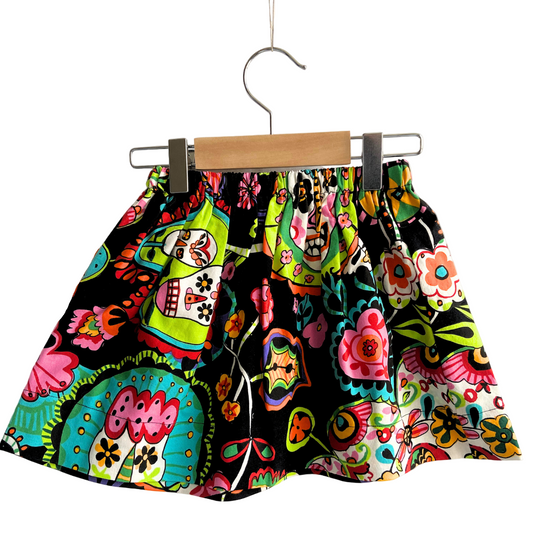 Colorful patterned skirt on a hanger against a white background
