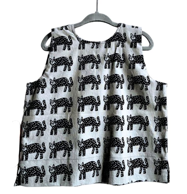 Children's box top with black animal pattern on a hanger against a white background