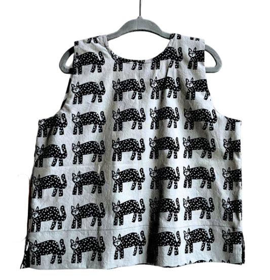 Children's box top with black animal pattern on a hanger against a white background