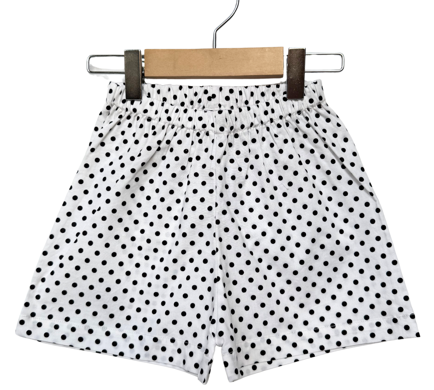 Polka dot shorts on a hanger against a white background