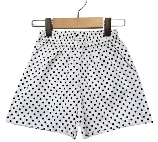 Polka dot shorts on a hanger against a white background