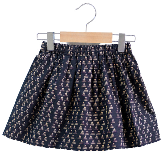 Skirt with geometric pattern on a hanger against a white background