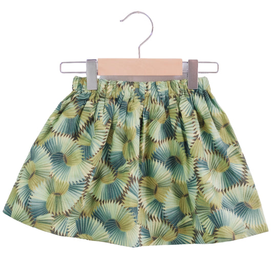 Green leaf-patterned skirt on a hanger against a white background