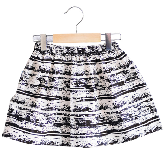 Black and white patterned skirt on a hanger against a white background